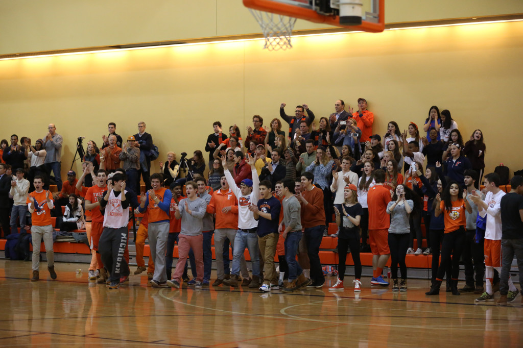 Photo by Jacob Cader: Fieldston fans cheer on the sidelines of basketball game against Hackley